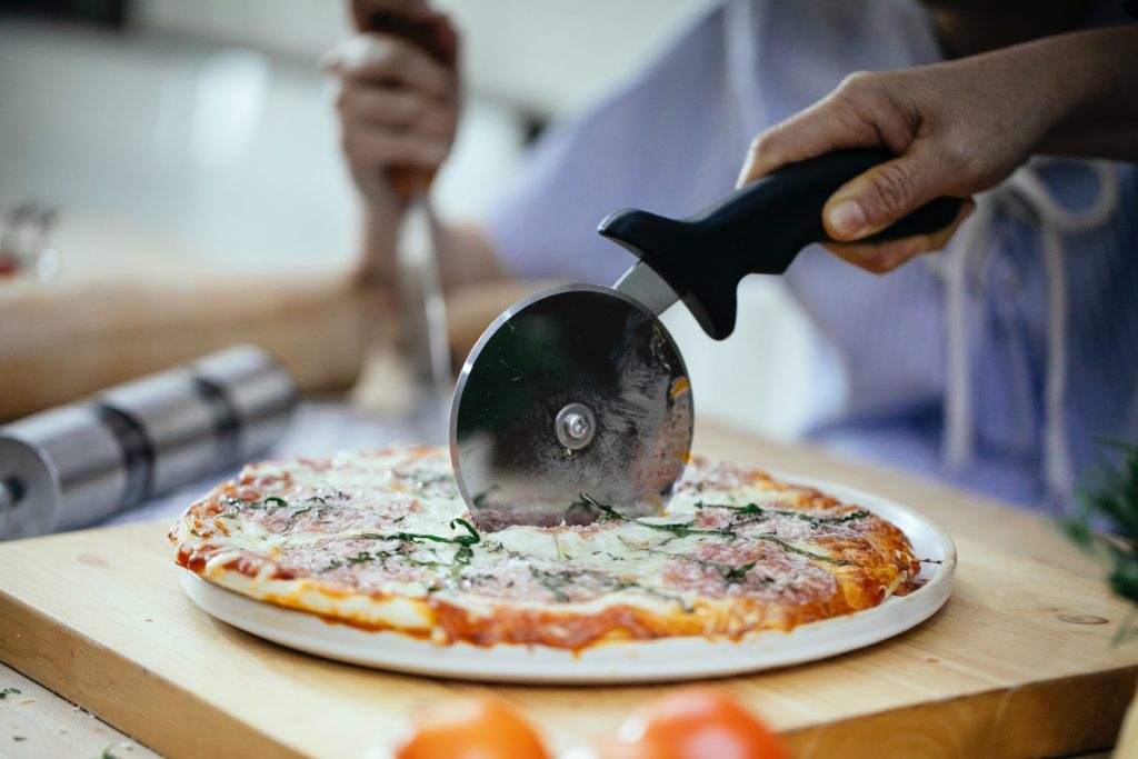 Pastry cutter cutting the pizza.